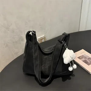 Minimalist black oversized shoulder bag with a cute white cloud charm and zipper closure
