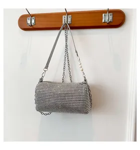 Detailed view of silver rhinestone handbag with metal chain and elegant pearl strap