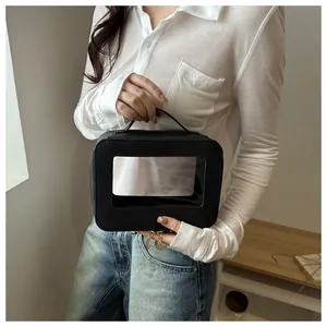 Detail of black PU leather organizer bag with transparent window and gold metal zippers