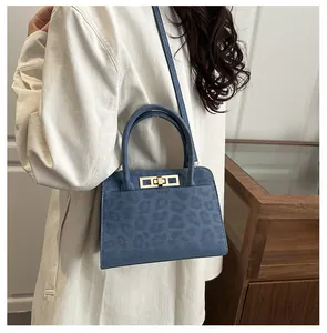 Gros plan du sac à main bleu à motif léopard avec fermoir tournant doré et poignée