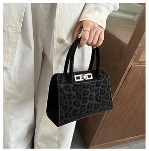 Détail du sac à main léopard avec fermoir rotatif doré et double poignée élégante