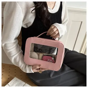 Pink portable makeup bag detail with large clear window and gold pendant zipper
