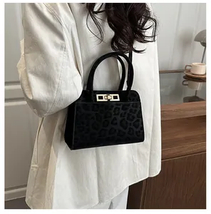 Détail du sac à main en fausse fourrure noire avec texture léopard et fermoir doré