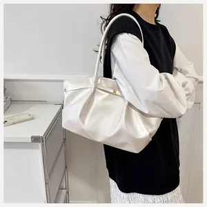 Dettaglio della borsa a spalla plissettata bianco perla con texture lucida e fibbia in metallo
