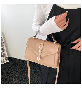 Detail of the chic beige crossbody bag with gold metal clasp and sleek envelope flap