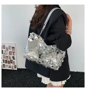 Détail du sac cabas à paillettes argentées avec chaîne en métal porté par un mannequin