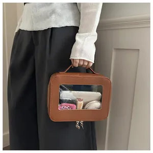 Detail view of large capacity brown travel makeup bag with transparent window and handle