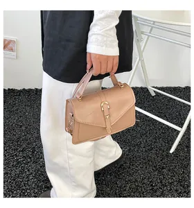 Detail of a beige vintage square handbag with gold metallic buckle and envelope flap