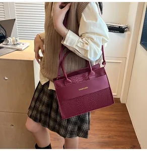 Dettaglio della borsa bordeaux con mix di texture liscia e stampa a serpente