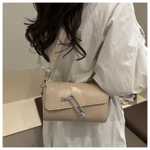 Détail du sac baguette beige en similicuir avec boucle métallique argentée en forme de U