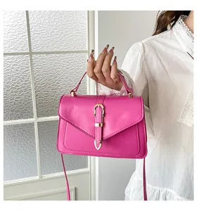 Detail of magenta envelope handbag with gold hardware and top handle for women