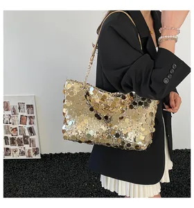 Gros plan des paillettes dorées sur un sac fourre-tout chic avec fine bandoulière chaîne