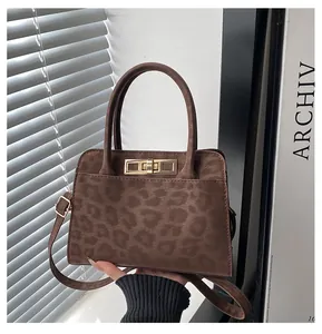 Détail du sac à bandoulière léopard vintage avec fermoir doré et texture en suède