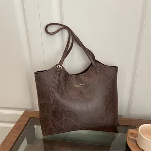 Minimalist dark brown tote bag with marble texture and adjustable shoulder strap
