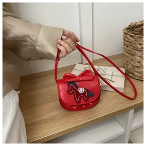 Détail du sac rouge matelassé pour fille avec nœud et poney brodé en décor chaleureux