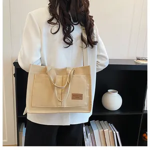 Détail du sac fourre-tout en toile kaki avec deux poches avant et bandoulière réglable pratique