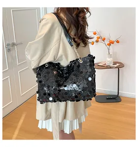 Détail de grands sequins noirs sur un sac cabas avec chaîne dorée et cuir