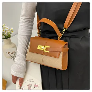 Détail du sac à bandoulière en cuir marron et tissé beige avec fermoir doré rotatif