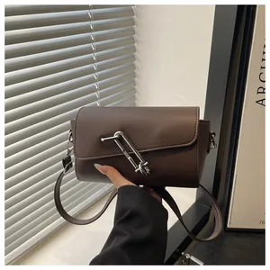 Détail du sac en cuir mat marron foncé avec boucle argentée en forme de trombone