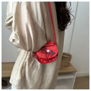 Détail du sac rouge bandoulière avec broderie poney et motifs cœur sur rabat matelassé