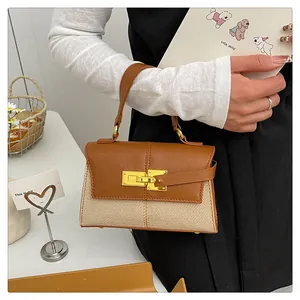 Détail d'un sac à main trapèze avec garniture en cuir marron et texture en tissu tissé beige