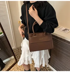 Dettaglio della borsa a mano marrone con trama coccodrillo e logo Fashion & Bags