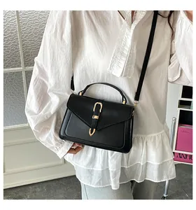 Classic black leather square handbag featuring a gold horseshoe metal buckle and top handle