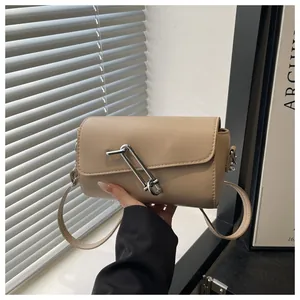 Gros plan sur un sac cylindrique marron clair avec boucle trombone argentée et cuir lisse