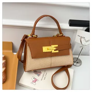 Détail d'un sac trapèze en cuir grainé marron avec des panneaux en tissu tissé beige