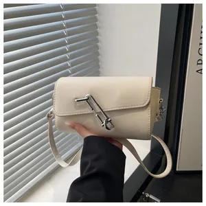 Détail du sac baguette crème avec une grande boucle épingle de sûreté argentée élégante