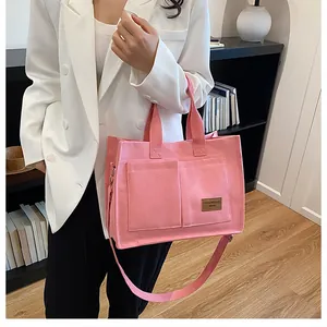 Détail du cabas en toile rose montrant les poches avant et l'étiquette de mode