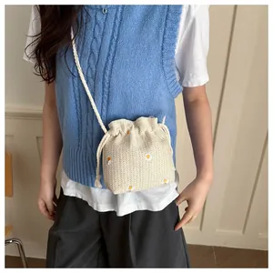 Close-up of woven bucket bag featuring daisy embroidery and practical drawstring closure
