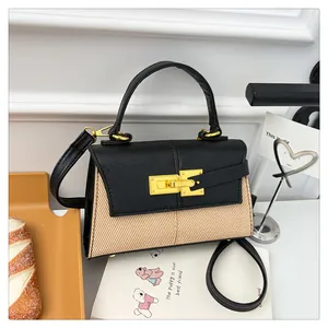 Gros plan sur le rabat en cuir noir et le fermoir doré rotatif d'un sac à main bicolore chic