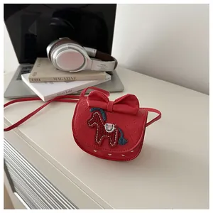 Détail du sac à bandoulière matelassé rouge pour fille avec nœud et poney brodé