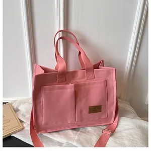 Détail du cabas en toile rose avec poches avant et bandoulière réglable pour le quotidien