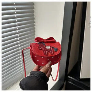 Détail du sac rouge avec nœud, matelassage en losange et broderie petit poney
