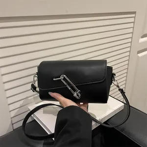 Bolso de hombro baguette minimalista en cuero negro con hebilla de imperdible plateada