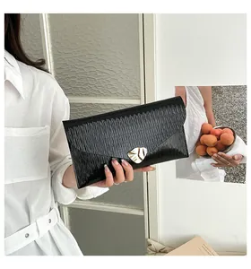 Detail der schwarzen Epi-Leder-Clutch mit goldener Blattschließe und V-Klappe