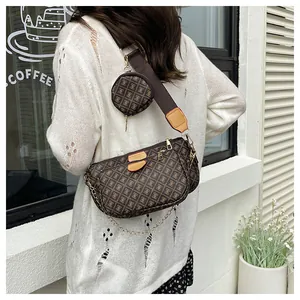 Close-up of brown monogram crossbody bag with small round pouch on wide strap