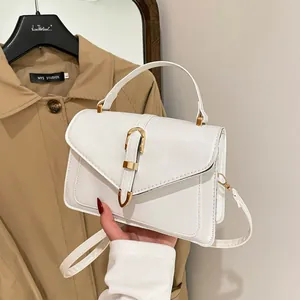 Minimalist creamy white leather crossbody bag with elegant gold horseshoe buckle