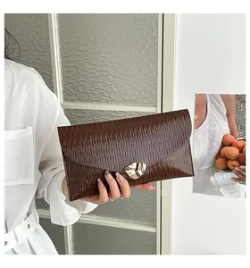 Details der dunkelbraunen Falten-Clutch mit einer einzigartigen goldenen Schließe