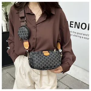Detail of crossbody bag with M-pattern print, wide strap, and detachable coin purse