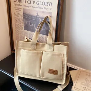 Sac fourre-tout minimaliste en toile beige avec grandes poches et bandoulière réglable