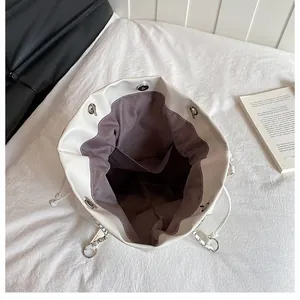 Détail intérieur d'un sac seau en cuir PU blanc avec cordon et fermoir magnétique