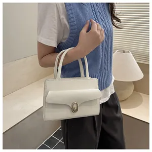 Close-up of white lychee pattern leather handbag with elegant gold metal twist lock
