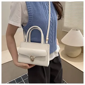 Detailed side view of a white pebble texture handbag with gold swivel lock and slim strap