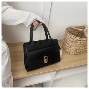 Close-up of black lychee grain leather handbag featuring elegant gold oval twist lock