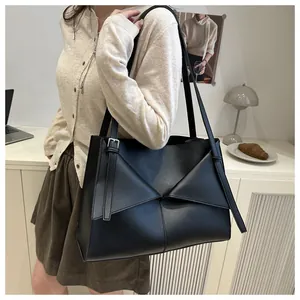 Detail of black geometric fold tote bag with matte finish and adjustable strap