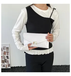 Detailaufnahme der weißen Umschlag-Clutch mit Wasserwellenstruktur und Blattverschluss