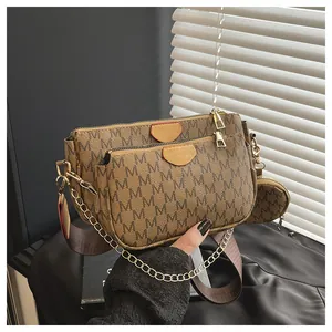 Detail of 3-in-1 crossbody bag featuring brown M-letter print and gold metal chain